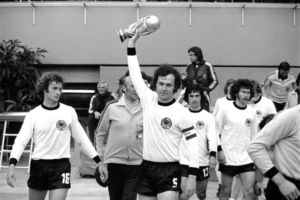 פרנץ בקנבאואר מחזיק את גביע העולם 1974, לצד חבריו לנבחרת מערב גרמניה (צילום: AP)