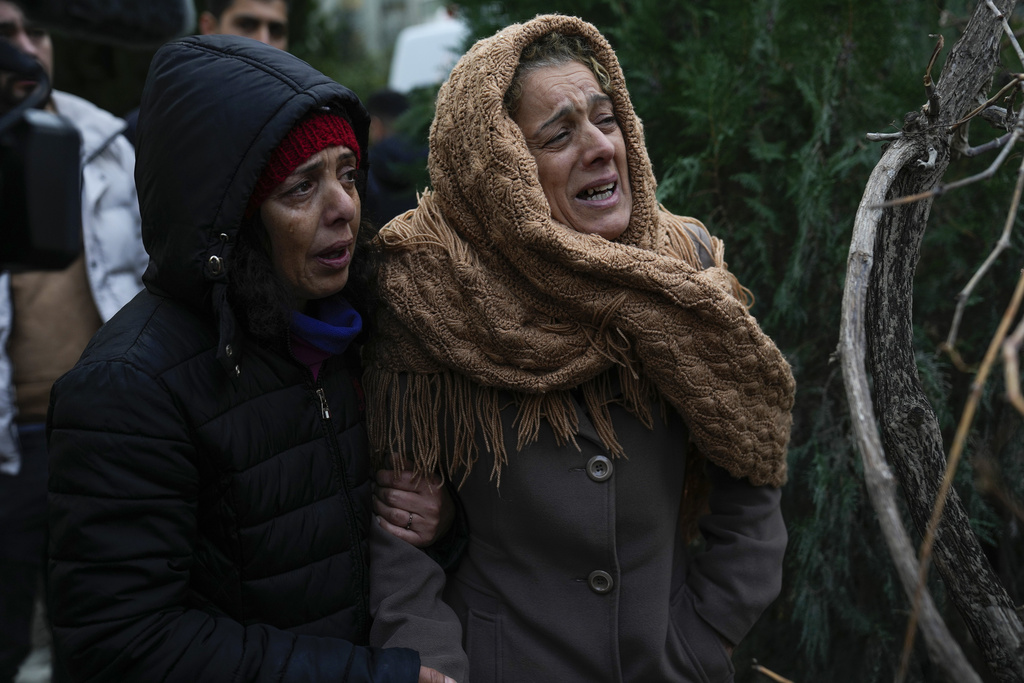 נשים מול בתיהן ההרוסים באדנה, טורקיה (צילום: AP Photo/Khalil Hamra, File)