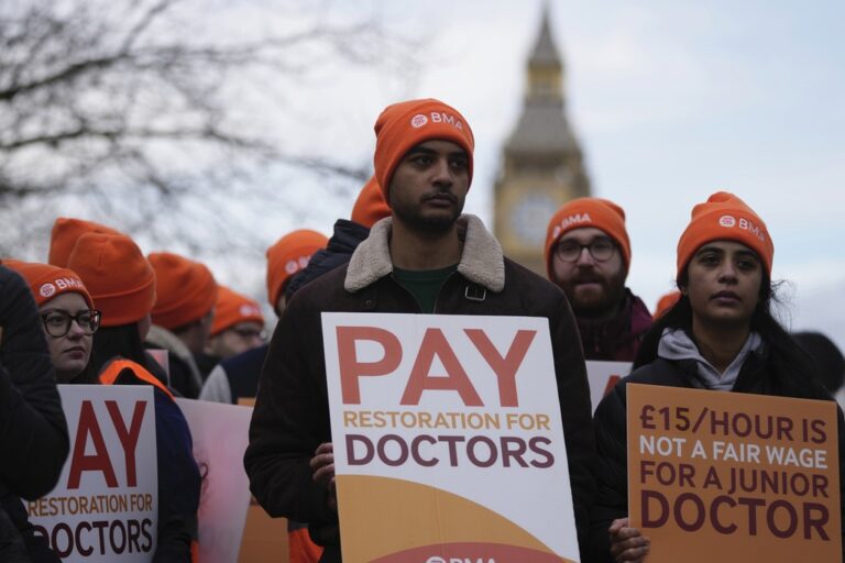 רופאים מפגינים בלונדון. על השלט מימין: &quot;15 ליש&quot;ט לשעה זה לא שכר הוגן לרופא מתחיל&quot; (צילום: AP Photo/Kin Cheung)