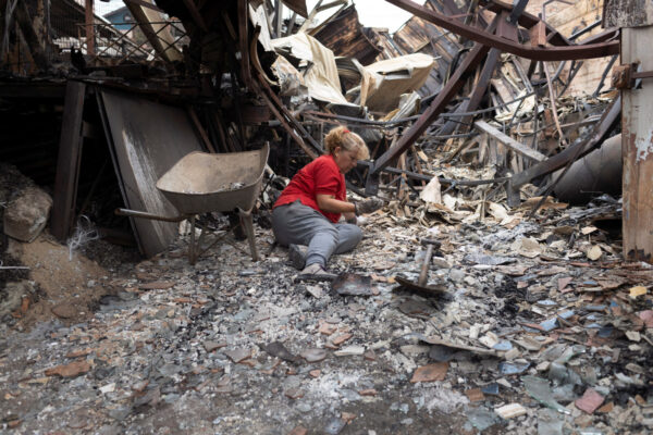 אישה בין שיירי ביתה שנשרף כליל, צ'ילה (צילום:  REUTERS/ Sofia Yanjari)