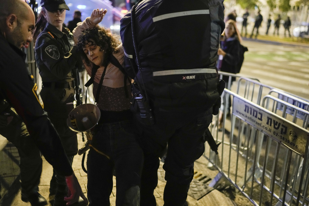שוטרים עוצרים מפגינה בהפגנת מחאה נגד הממשלה בדרך מנחם בגין בתל אביב (צילום: AP Photo/Leo Correa)