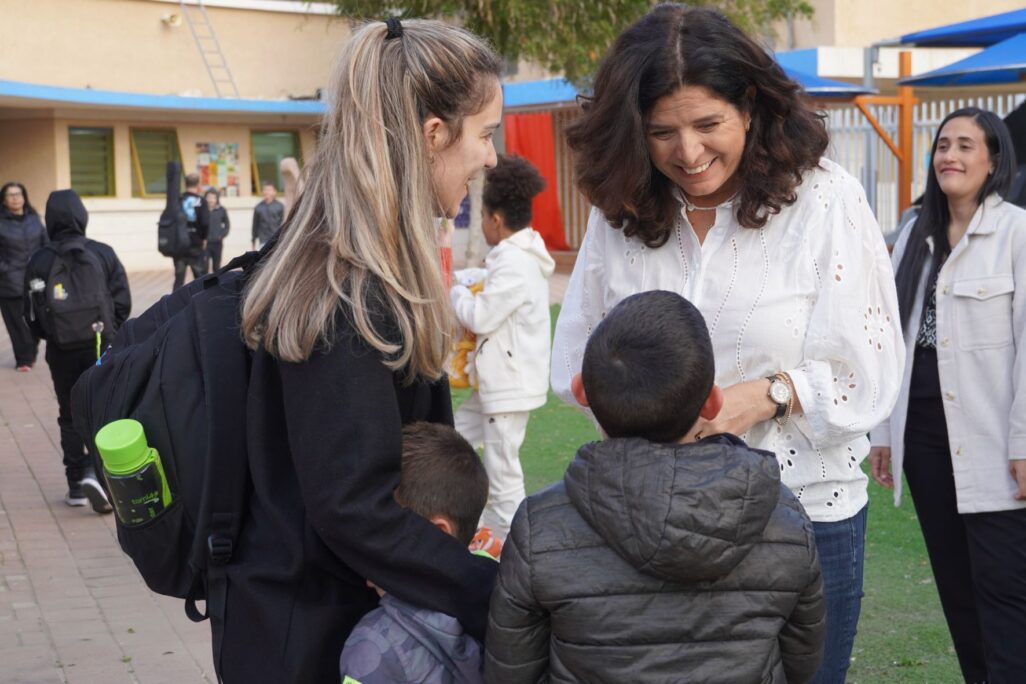 מנהלת בית הספר היסודי מעוז-שקמים בשדרות, איילה חדד, עם ילד ואמו ביום החזרה ללימודים לאחר שישה חודשי מלחמה (צילום: סוניה גרשפט)