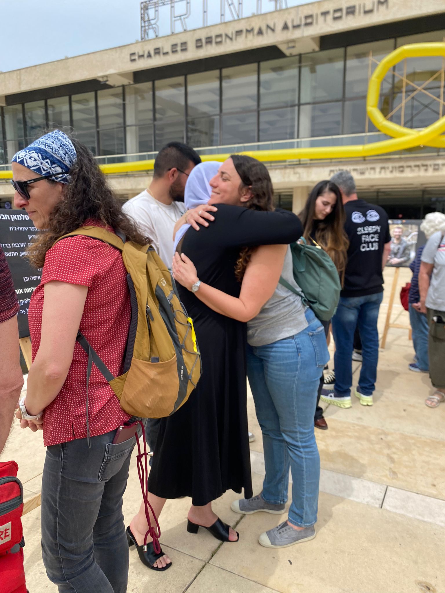 Two attendees embrace at the exhibition (Photo: Yahel Farag)