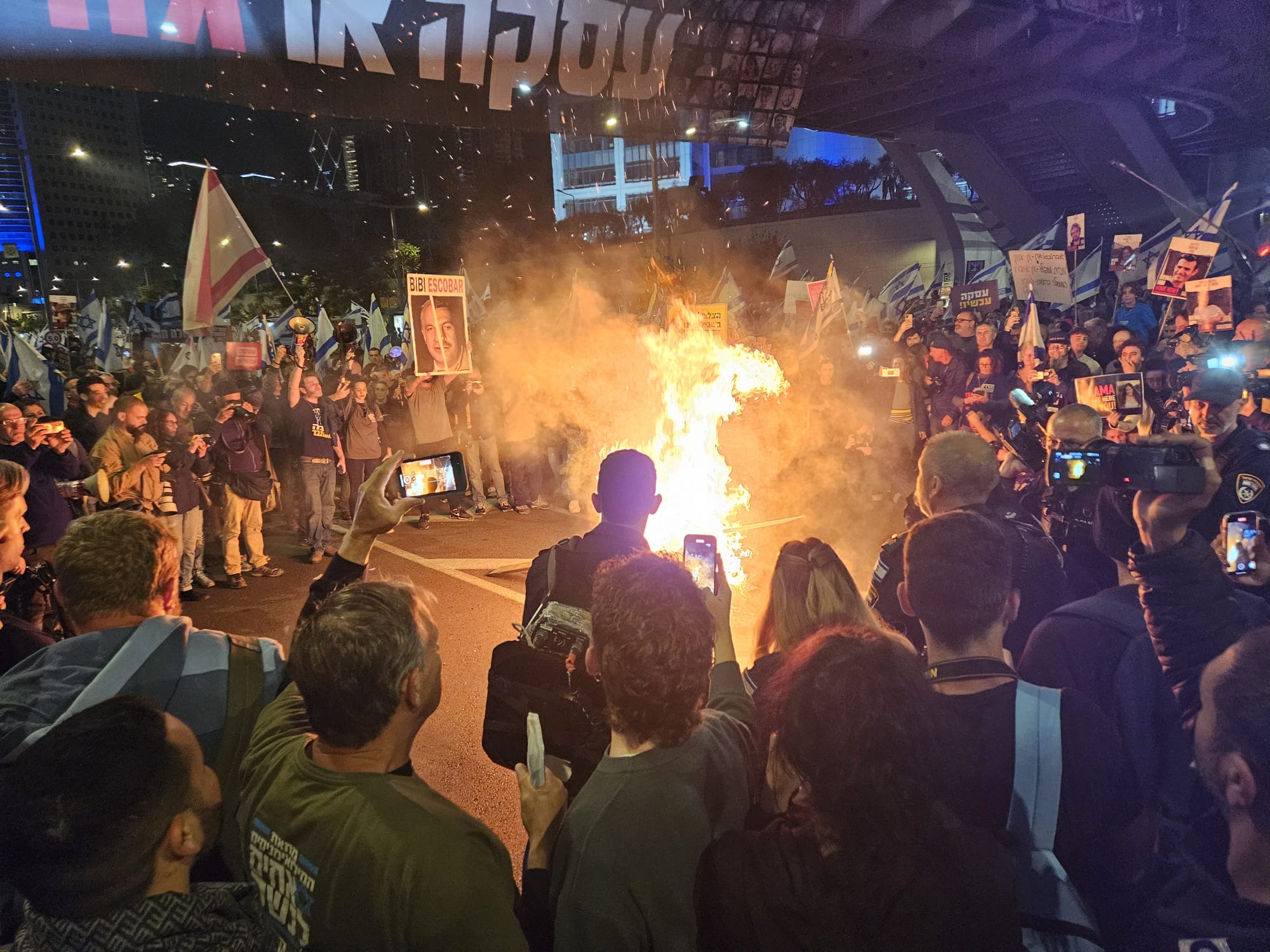 מפגינים ובני משפחות חטופים מבעירים מדורה מול הקריה בתל אביב (צילום: דורון הבסי)