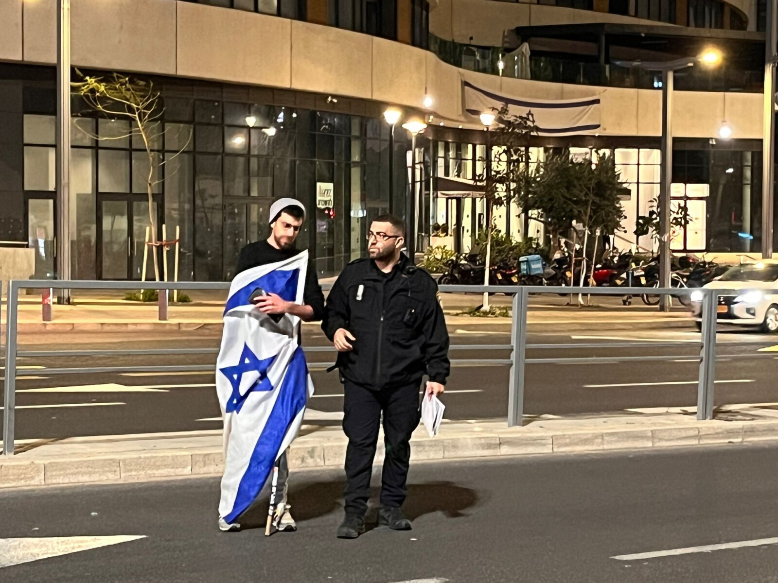 Demonstrator for the return of the abductees on Begin Road in Tel Aviv with a policeman who fined him 1,000 shekels for going down the road (Photo: Oren Dagan)