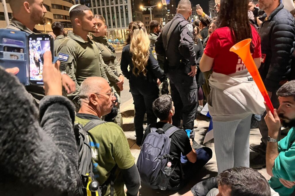 שוטרים עומדים בסמוך למפגינים למען החזרת החטופים חוסמים את התנועה במחלף ארלוזורוב בתל אביב (צילום: אורן דגן)