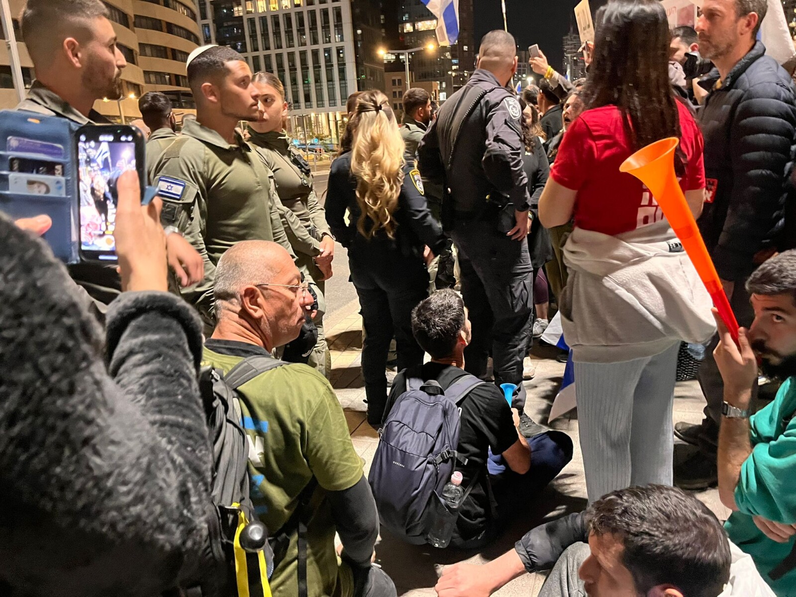 שוטרים עומדים בסמוך למפגינים למען החזרת החטופים חוסמים את התנועה במחלף ארלוזורוב בתל אביב (צילום: אורן דגן)