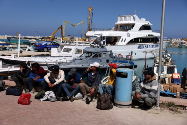מהגרים ממתינים בנמל דיג בקפריסין (צילום: REUTERS/Yiannis Kourtoglou)