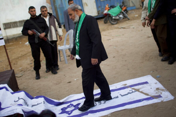 בכיר חמאס מחמוד א זהאר דורך על דגל ישראל שעליו הכיתוב "תושמד לבטח". (צילום ארכיון:  (AP Photo/Bernat Armangue)
