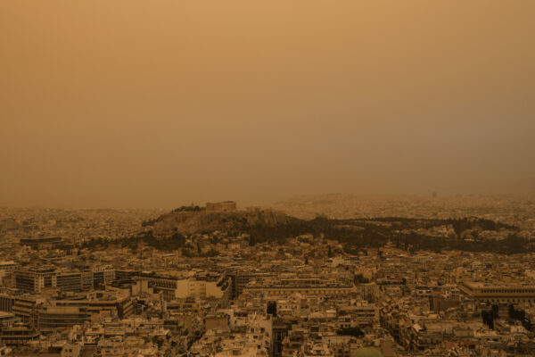 שמיים כתומים באתונה, בעקבות אבק שהגיע מכיוון אפריקה (צילום: AP Photo/Petros Giannakouris)