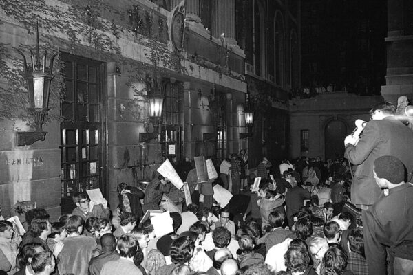 1968: התומכים בסטודנטים שהשתלטו על בניין המילטון מתקבצים מחוץ לבניין ומתגוננים מזריקת ביצים (צילום: AP Photos/Dave Pickoff)