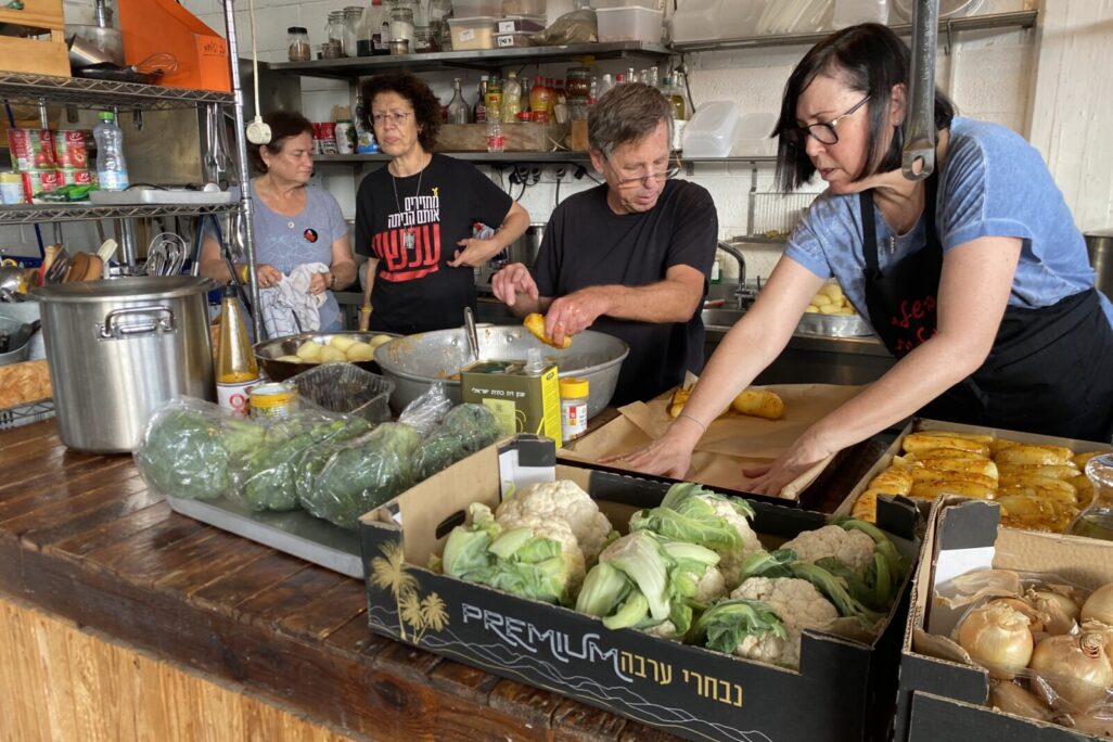 משפחתו של יגב בוכשטב החטוף בעזה ומתנדבים נוספים מכינים אוכל, שיחולק לנזקקים בדרום ת&quot;א (צילום: יהל פרג')