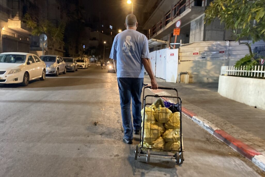 איציק עם העגלה עמוסה באוכל, בדרך לחלוקה ברחובות דרום תל אביב (צילום: יהל פרג')