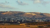 היישוב נגוהות בדרום הר חברון (על הגבעה), מעל הכפר בית עווא (צילום: ויקימדיה קומונס)