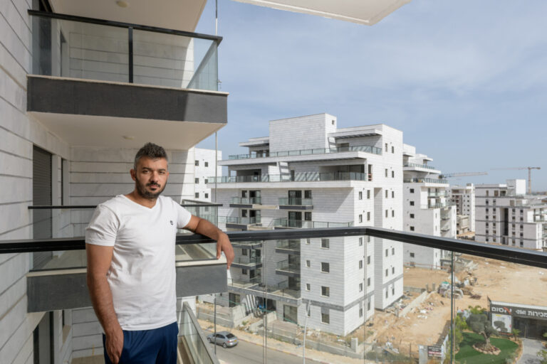 Elroi Benita on the balcony of the apartment he bought in Sderot. “I wanted to rent out the apartment for extra income, but in the end, I found myself living in it.” (Photo: Yonatan Blum)