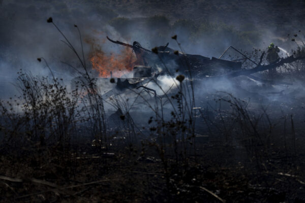 כבאים מכבים שריפה סמוך למושב רמות נפתלי בגליל העליון, שנגרמה כתוצאה מרקטות ששיגר חיזבאללה (AP Photo/Ariel Schalit)