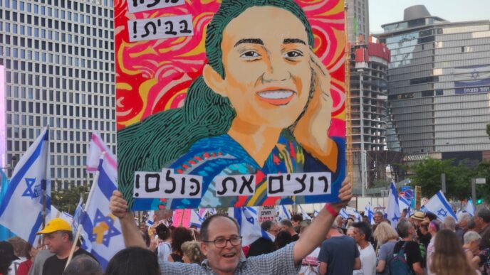 זאב אנגלמאיר מניף כרזה שאייר למען שחרורה של נועה ארגמני בצומת קפלן בת&quot;א (צילום: דורון הבסי)