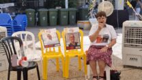 תמי הלוי לצד תמונותיהם של החטופים עמרי מירן וצחי עידן (צילום: הדס יום טוב)