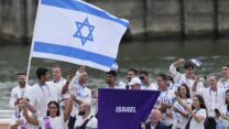 אנדראה מורז ופיטר פלצ'יק נושאים את דגל ישראל בטקס פתיחת המשחקים האולימפיים בפריז (צילום: AP/Kirsty Wigglesworth)