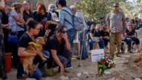 רימון קירשט (יושבת, מימין), אלמנתו של יגב בוכשטב ז"ל שנחטף ונרצח לעזה על ידי ארגון חמאס, בהלווייתו בקיבוץ נירים (חיים גולדברג / פלאש 90)