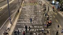 שמות החטופים בכביש הכניסה לקריה בתל אביב (צילום: אייל אדר)