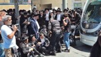 מוחים חוסמים את הרכבת הקלה ליד לשכת הגיוס בירושלים (צילום: אור גואטה)