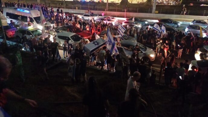 מפגינים למען שחרור החטופים חוסמים את נתיבי איילון ונושאים ארון קבורה (צילום: גל רקובר)