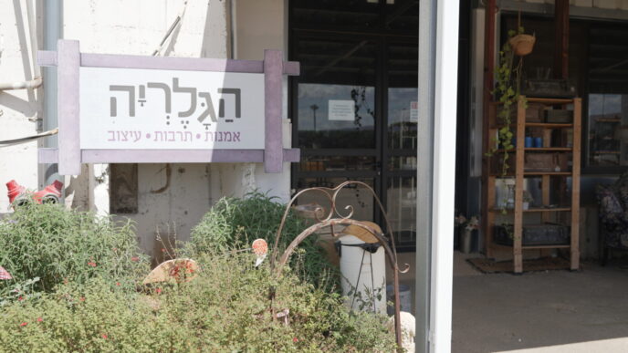 הכניסה לגלריה. גם כשהמקום סגור, רוני משאירה שלט בכניסה שמזמין את מי שמגיע להתקשר אליה, כדי שתבוא לפתוח (צילום: סוניה גרשפט)