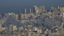 עשן מיתמר באזורים שהותקפו בדאחייה (צילום: AP Photo/Hussein Malla)