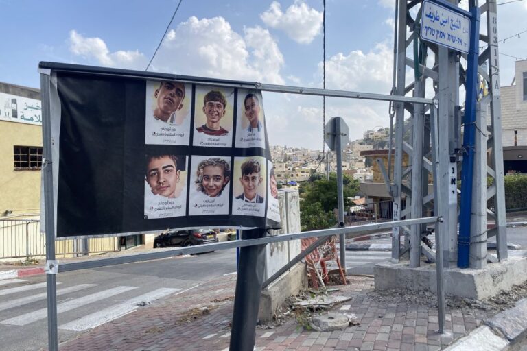 הכיכר הסמוכה לבית העם בשפרעם. שלט עם תמונות הילדים ממג'דל שמס מתנופף ברוח (צילום: יהל פרג')
