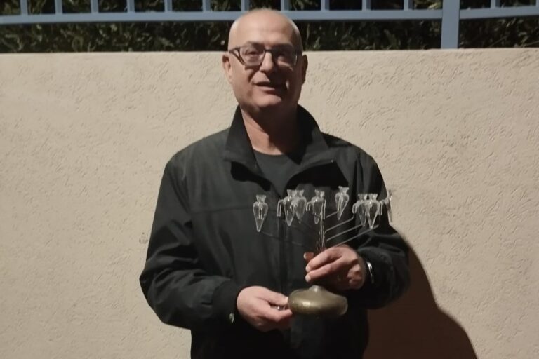 עופר גולן עם החנוכייה של אביו, שחולצה מהבניין (צילום: אמיתי פרץ)