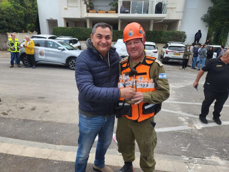 אורן גולן עם סא"ל במיל' עופר פרובלר, מג"ד פיקוד העורף בחיפה שסייע בחילוץ חפצים מהבניין, ועם החנוכייה שחולצה (צילום: עופר גולן)