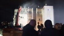 עופר ואורן גולן צופים בהריסת הבניין שבו גדלו (צילום: אמיתי פרץ)