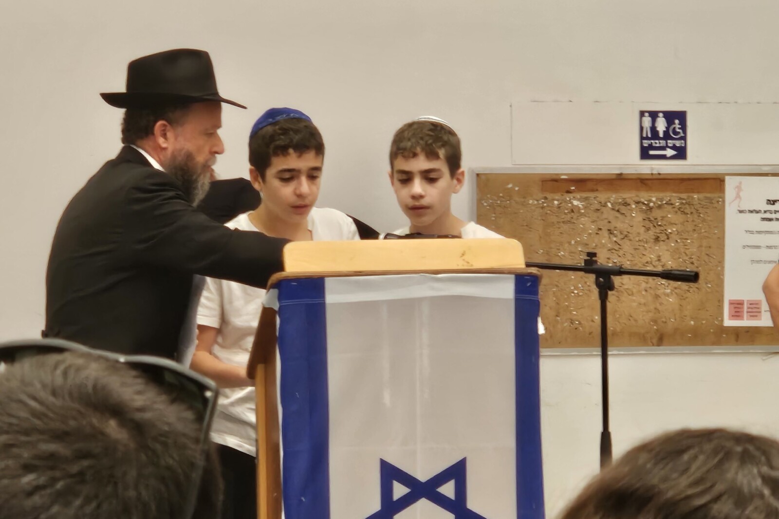 בניו של עומר ויינשטיין, איתמר (מימין) וישי, אומרים קדיש על אביהם (צילום: מאיה רונן)