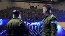מפקד עיר הבה"דים, אל"ם ערן כהן, מדליק נר ראשון של חנוכה עם אלפי חיילים מהקורסים בבסיס ורב הבסיס, רס"ן ליאור בנימין (צילום: דובר צה"ל)