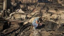 תושב פליסייד, לוס אנג'לס, ליד הריסות ביתו (צילום: AP Photo/John Locher)