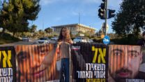 מפגינה עם תמונות חטופים מול הכנסת (צילום: תניא ציון וולדקס)