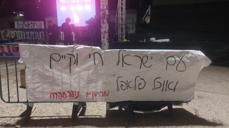 שלט הזמנה לדוכן הפלאפל של בני הנוער ממועצה אזורית בנימין בכיכר החטופים. "עם ישראל חי וקיים ואוכל פלאפל" (צילום: מיכל מרנץ)