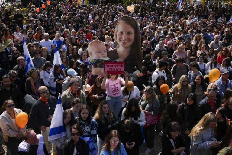 צפייה בשידור ההלוויה בכיכר החטופים (צילום: AP Photo/Ariel Schalit)