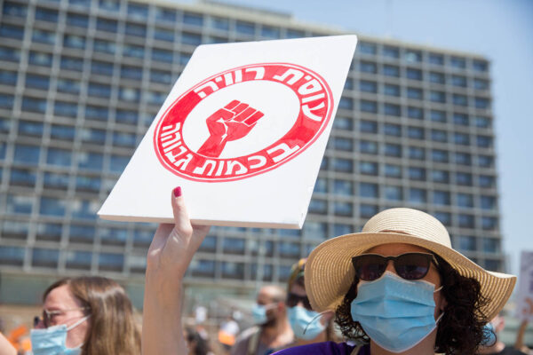 עובדת סוציאלית בהפגנה (צילום: מרים אלטשר/פלאש90)