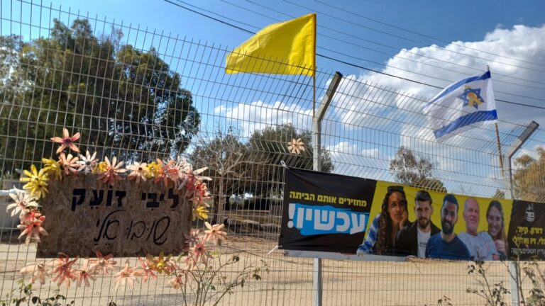 שלט עם תמונות החטופים מקיבוץ כפר עזה על גדר קיבוץ רוחמה, בו מתגוררים באופן זמני חברי הקיבוץ (צילום: אוריאל לוי)