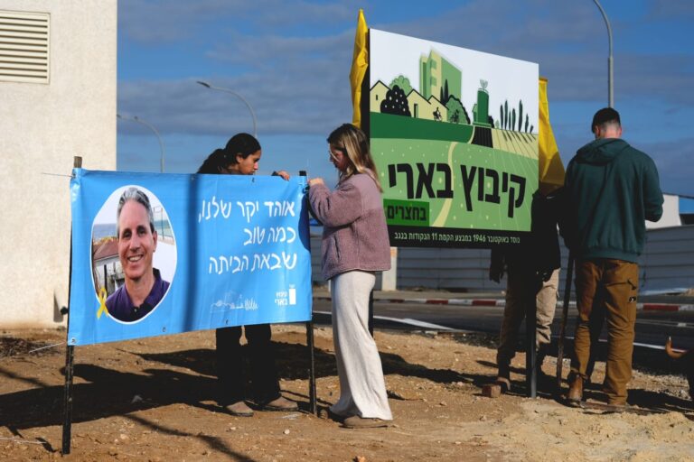 חברי קיבוץ בארי תולים שלטים לקראת חזרתם של אלי שרעבי ואוהד בן עמי משבי חמאס (צילום: דוד טברסקי)