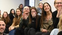 גל פרטקובניק (יושבת, שלישית מימין) עם החברים של סשה, צופים בשחרורו (צילום: פאולינה פטימר)