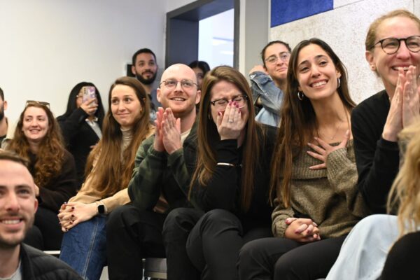 גל פרטקובניק (יושבת, שלישית מימין) עם החברים של סשה, צופים בשחרורו (צילום: פאולינה פטימר)