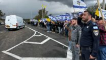 שוטרים ואזרחים סמוך לשיירה המלווה את ארונותיהם של החללים החטופים (צילום: דוברות המשטרה)
