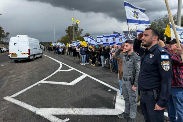 שוטרים ואזרחים סמוך לשיירה המלווה את ארונותיהם של החללים החטופים (צילום: דוברות המשטרה)