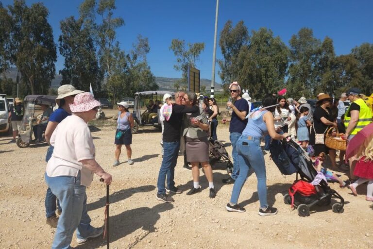 אנשי הקהילה מברכים זה את זו בשובם לקיבוץ מעין ברוך (צילום: מאיה רונן)