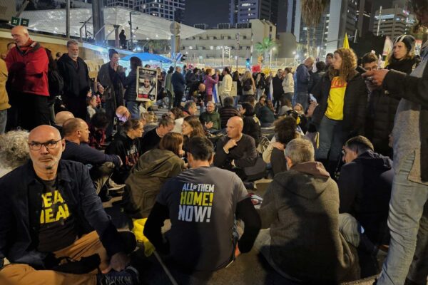 מפגינים למען שחרור החטופים יושבים על שדרות שאול המלך בתל אביב סמוך לשער בסיס הקריה (צילום: דורון הבסי)