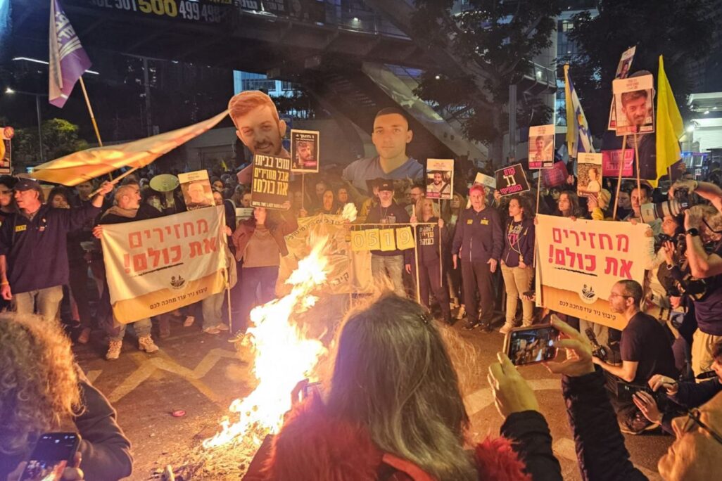 מפגינים למען שחרור החטופים סביב מדורה שהדליקו על דרך בגין בתל אביב (צילום: דורון הבסי)