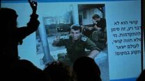 מצדה כשמאחוריה מצגת עם תמונתו של אחיה חן בוכריס ז"ל